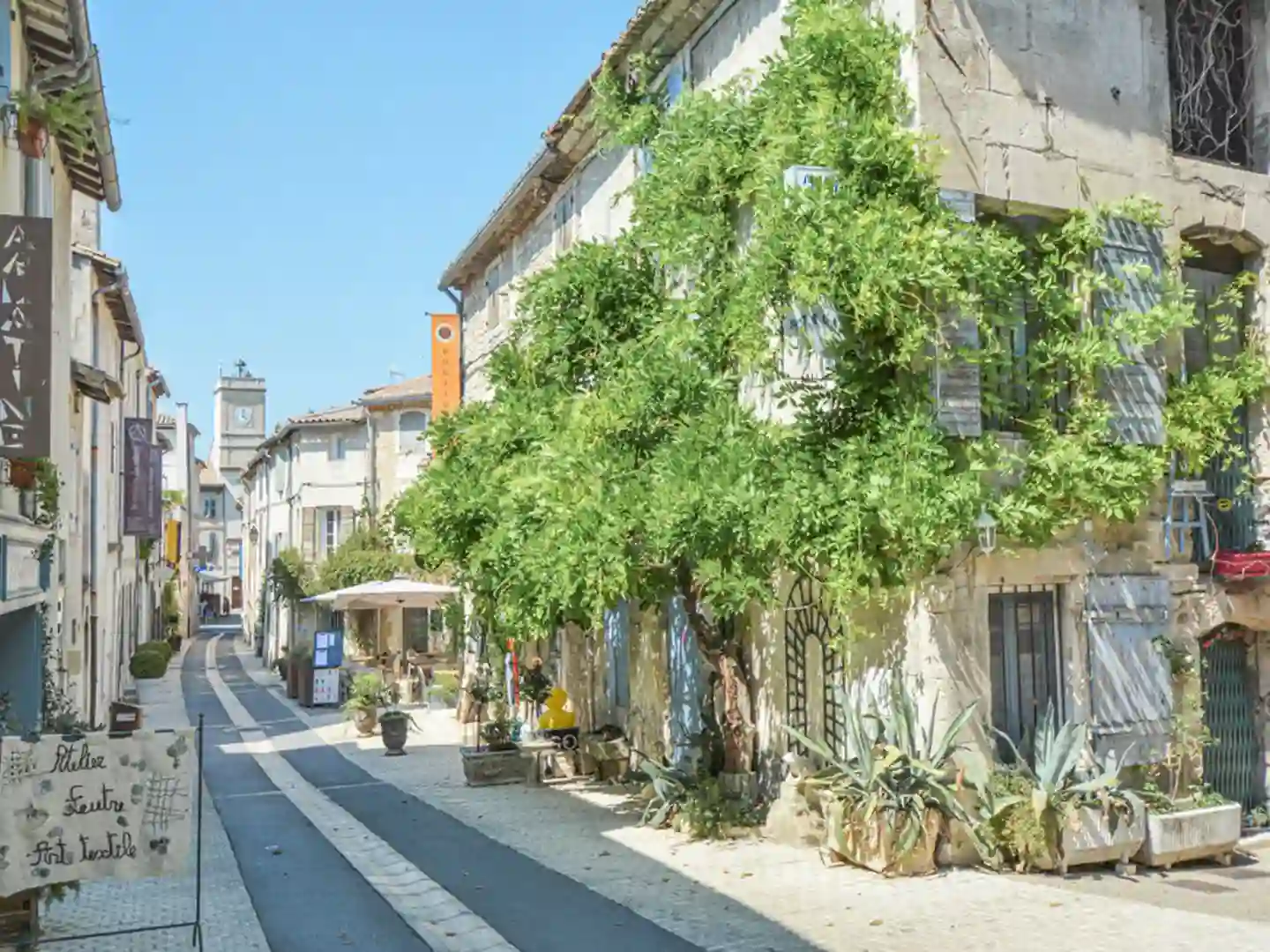 Rue de Cabannes, un village provençal avec ses bâtiments traditionnels, son horloge et ses espaces verdoyants, dans un cadre paisible et typique de la région.