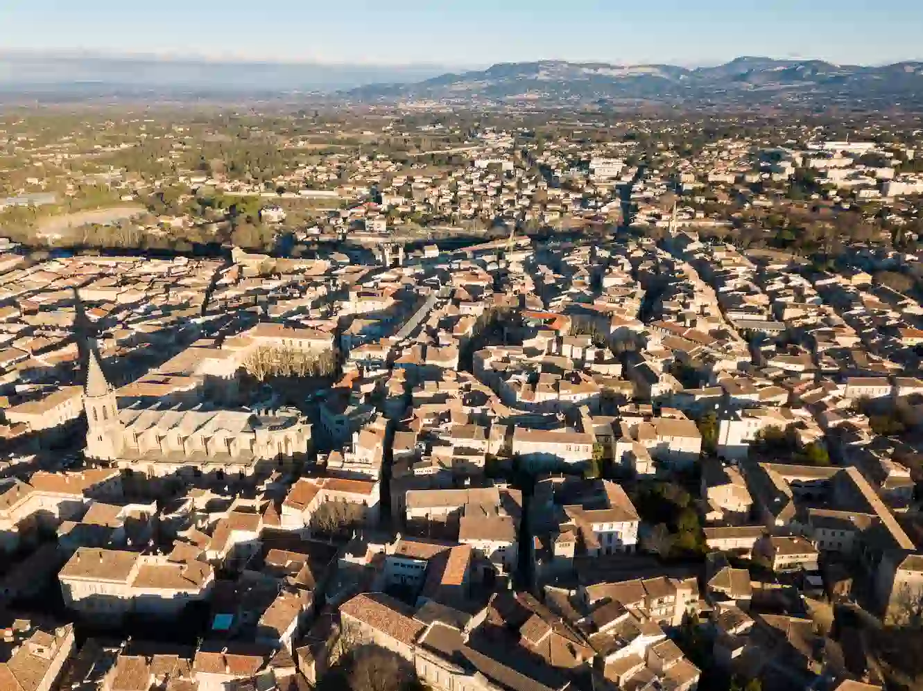 Vue aérienne de Lauris, montrant le centre-ville et les toits provençaux, avec le Mont Ventoux en arrière-plan